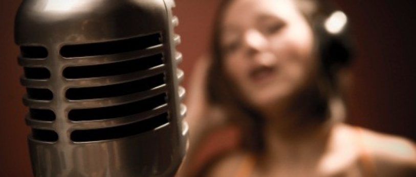 Shallowly Focused Young Woman Singing into Microphone